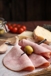 Slices of tasty ham with olive on table, closeup