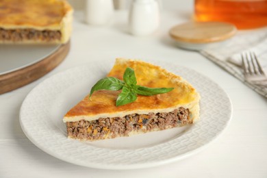 Photo of Piece of delicious pie with minced meat on white table