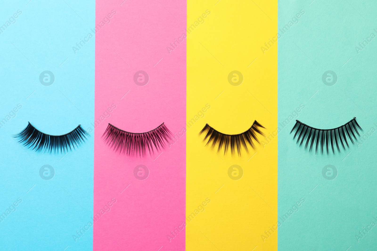 Photo of False eyelashes on color background, flat lay