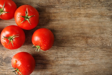 Fresh ripe tomatoes on wooden table, flat lay. Space for text