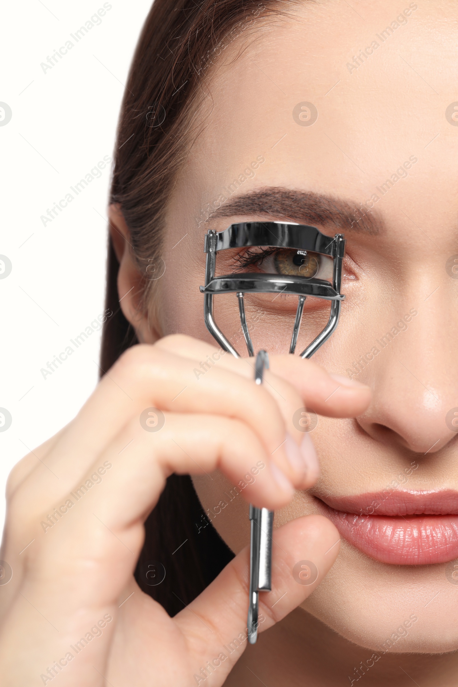 Photo of Woman using eyelash curler on white background, closeup