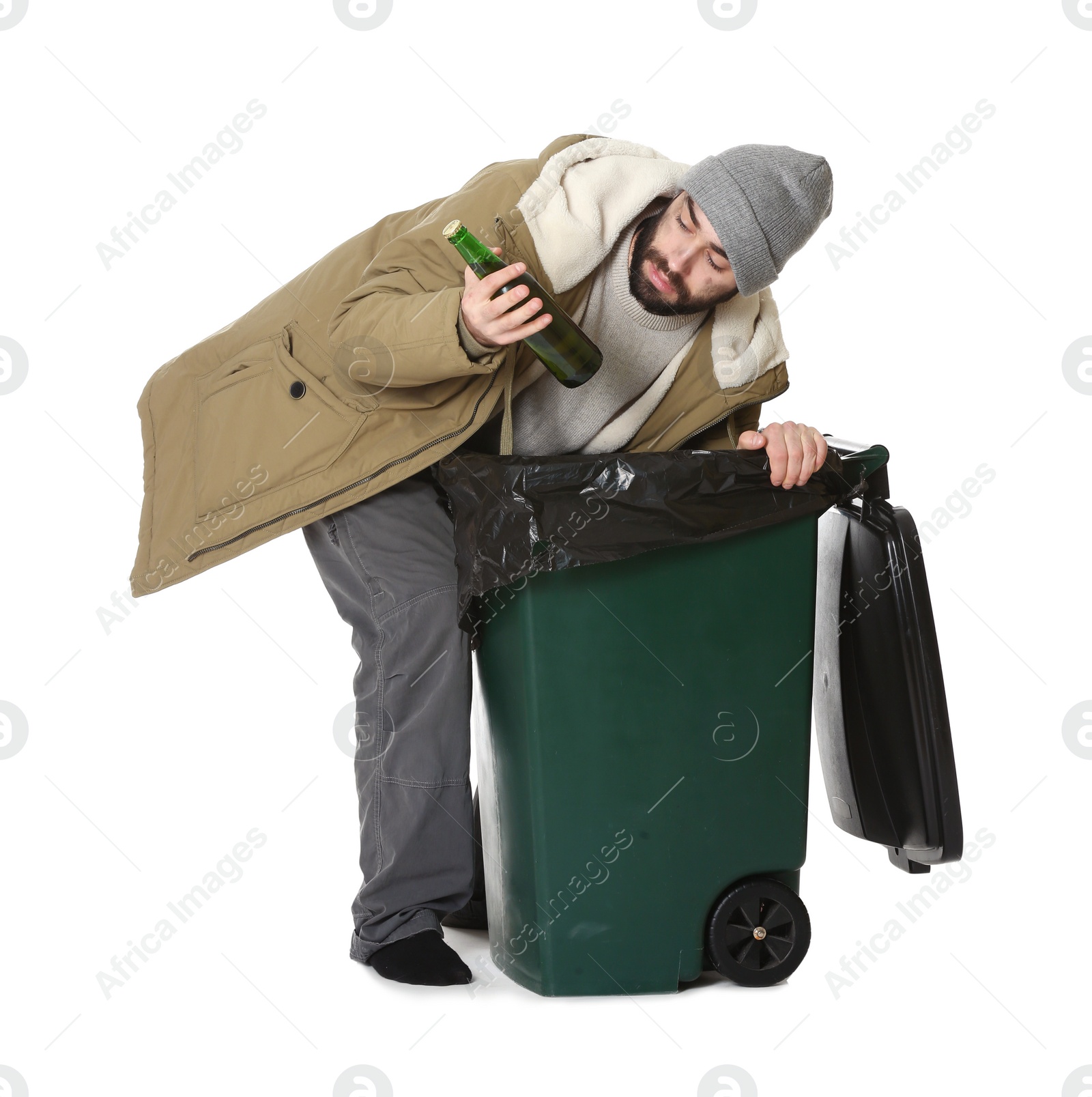 Photo of Poor homeless man digging in trash bin isolated on white