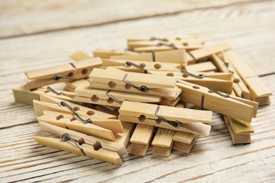 Photo of Pile of clothes pins on white wooden table, closeup