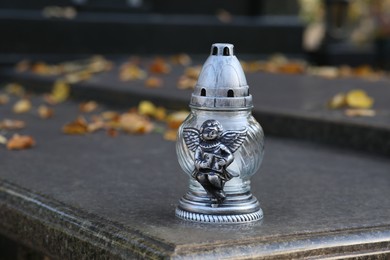 Photo of Grave lantern on granite surface in cemetery