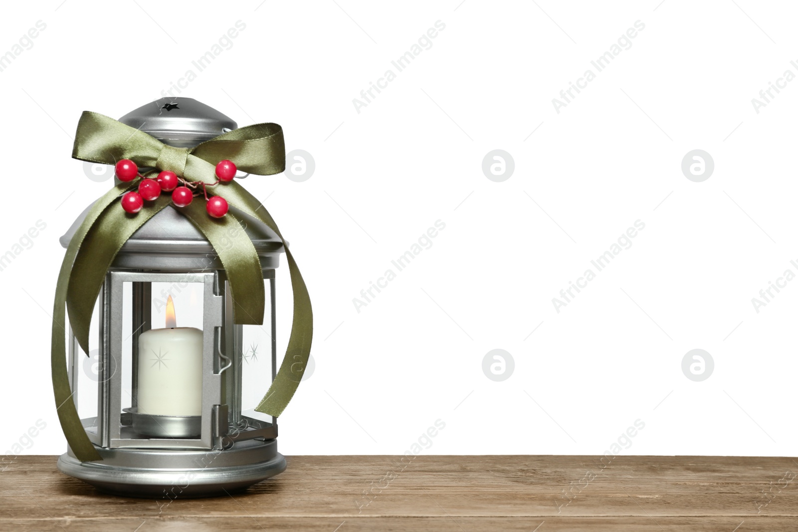 Photo of Decorated Christmas lantern with burning candle on wooden table, space for text