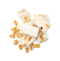 Photo of Pieces of delicious nougat and nuts on white background, top view