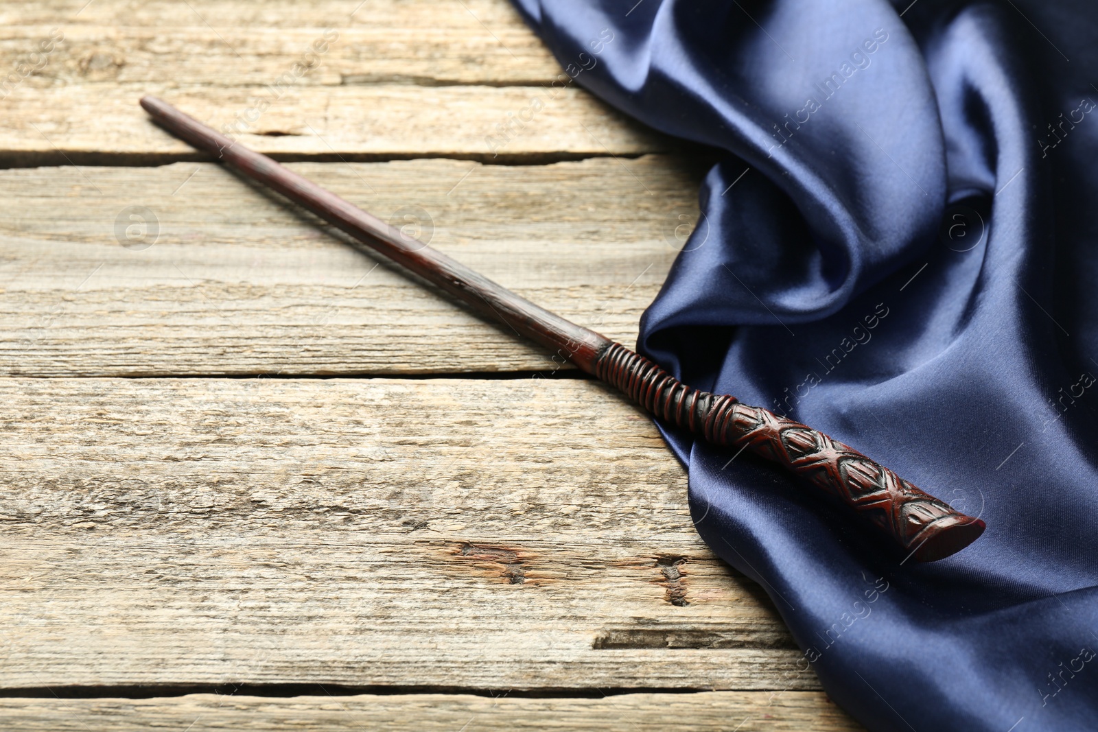 Photo of Old magic wand and fabric on wooden table