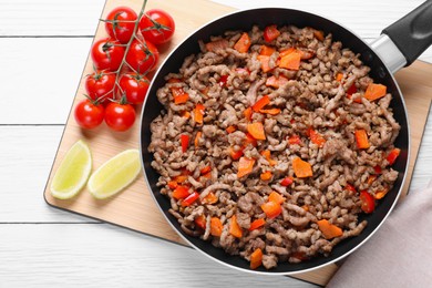 Photo of Delicious minced meat with carrot, pepper and tomatoes on white wooden table, flat lay