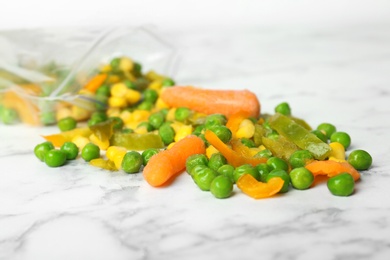 Photo of Mix of frozen vegetables on marble table, closeup