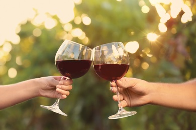 Photo of Couple with glasses of red wine outdoors, closeup
