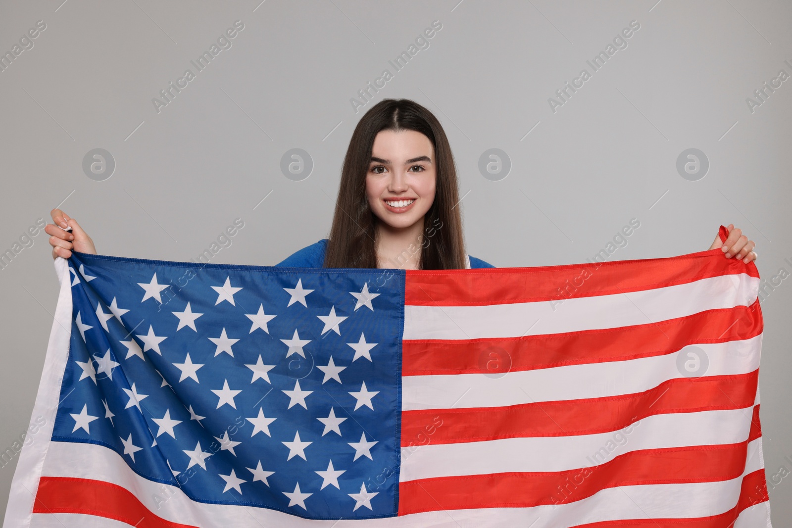 Photo of 4th of July - Independence Day of USA. Happy girl with American flag on grey background