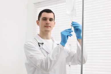 Photo of Doctor setting up IV drip in hospital