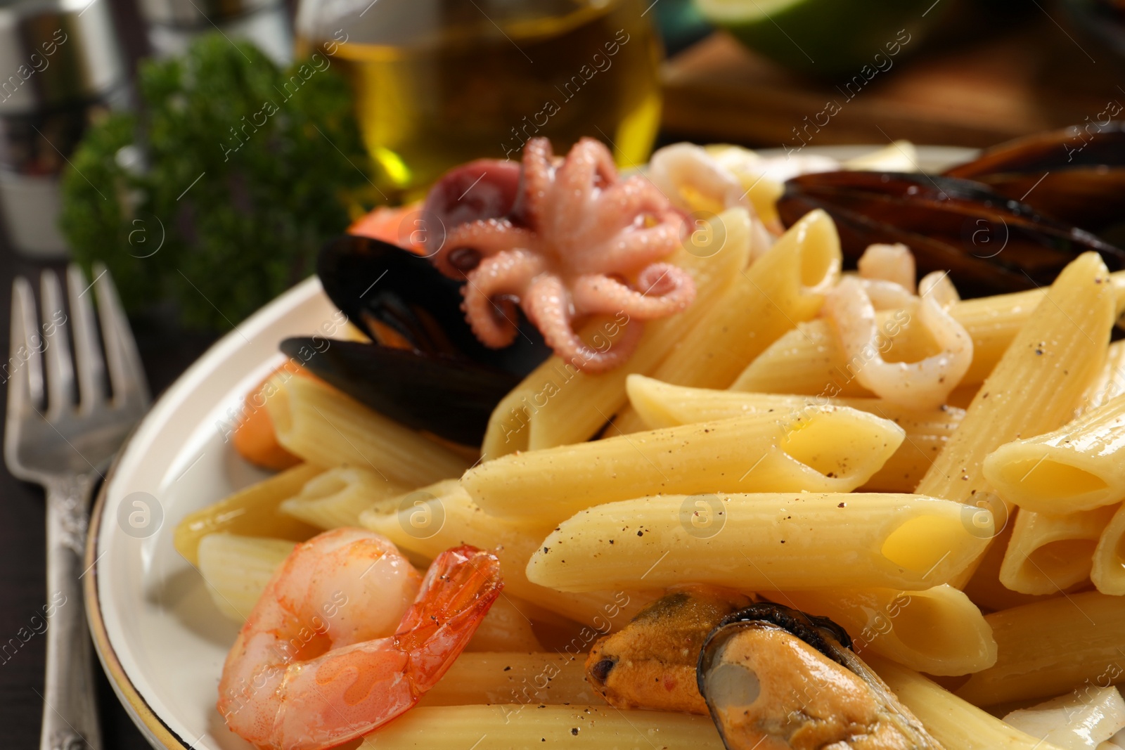 Photo of Delicious pasta with seafood on plate, closeup