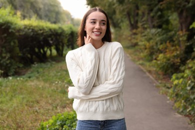 Photo of Beautiful young woman in stylish warm sweater outdoors