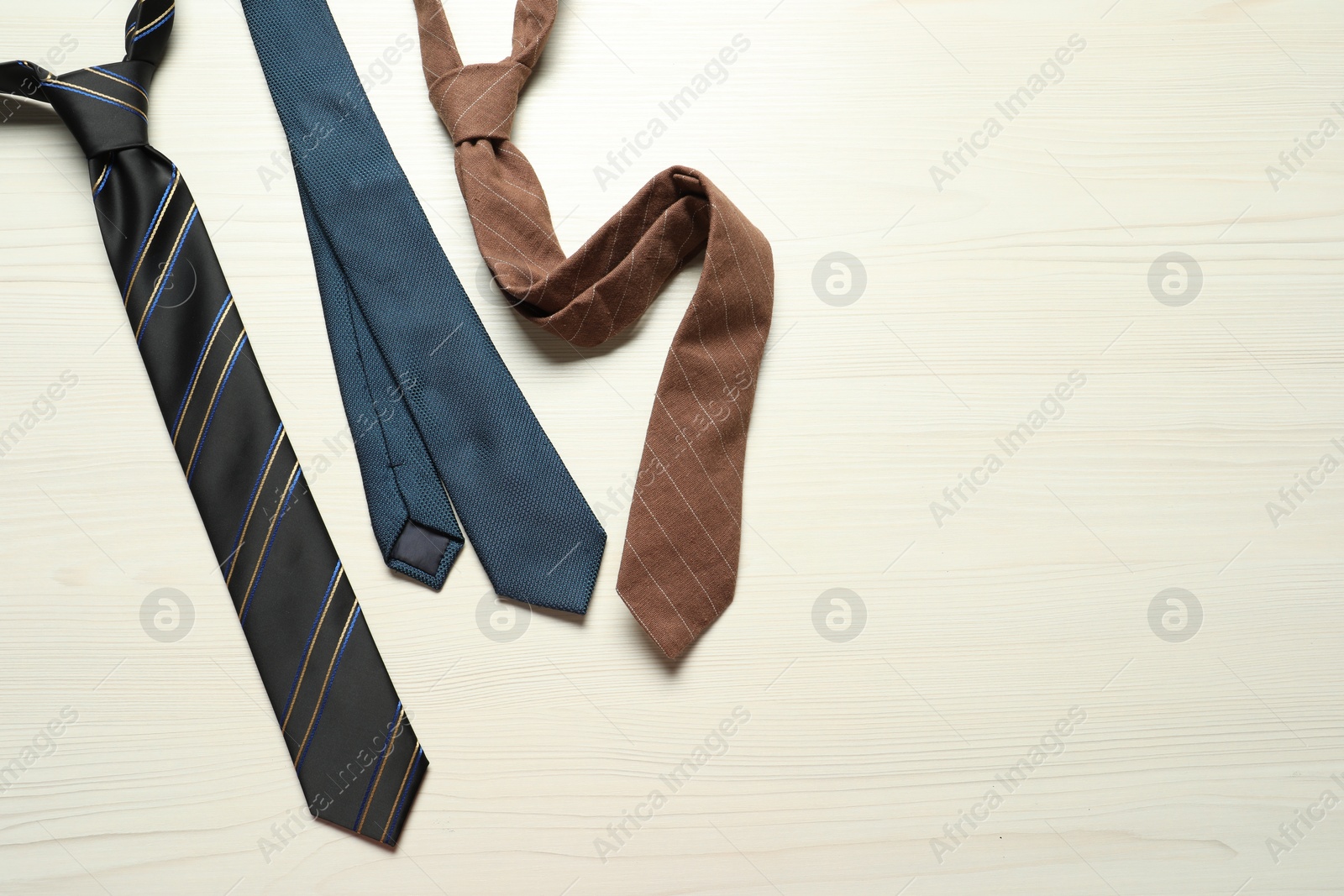 Photo of Different neckties on white wooden table, flat lay. Space for text