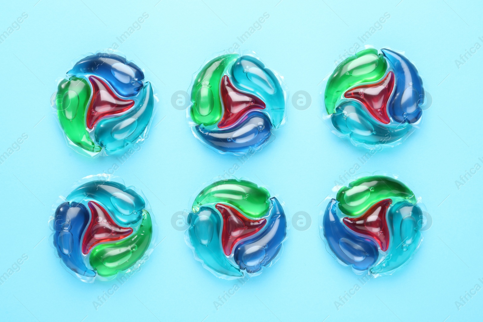 Photo of Laundry capsules on turquoise background, flat lay