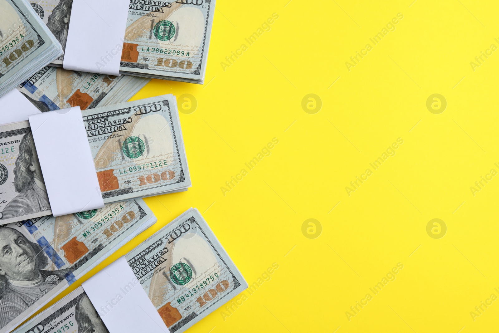 Photo of Dollar banknotes on yellow background, flat lay. Space for text