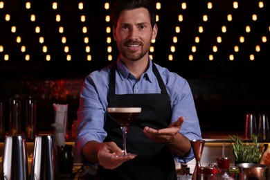 Photo of Bartender with Espresso Martini in bar. Alcohol cocktail