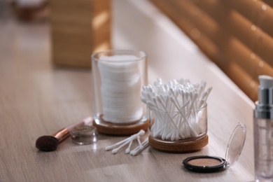 Photo of Cotton buds and pads on wooden surface indoors