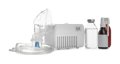 Modern nebulizer with face mask and medications on white background. Inhalation equipment