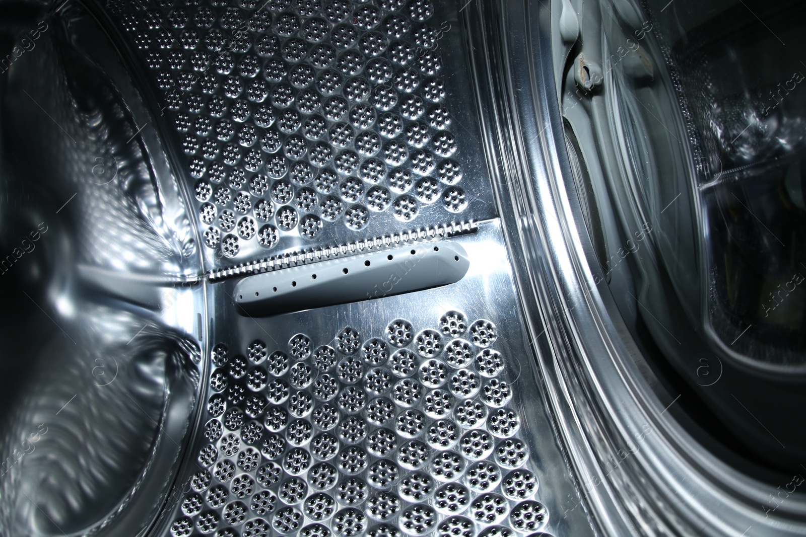 Photo of Empty washing machine drum, closeup view. Laundry day