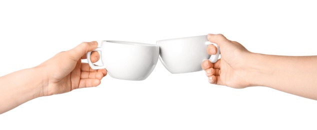 Photo of Women clinking cups on white background, closeup