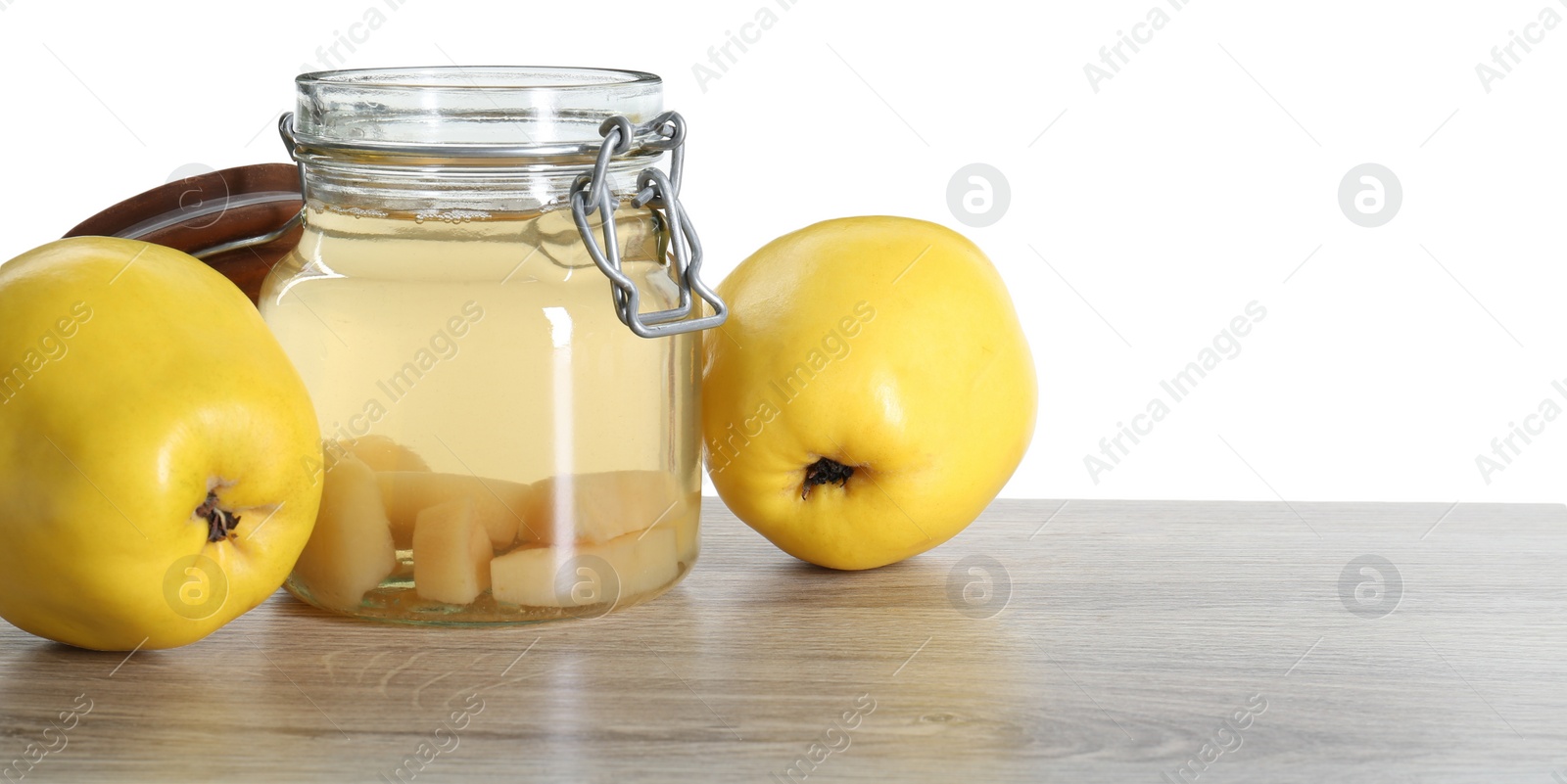 Photo of Delicious quince drink and fresh fruits on wooden table against white background