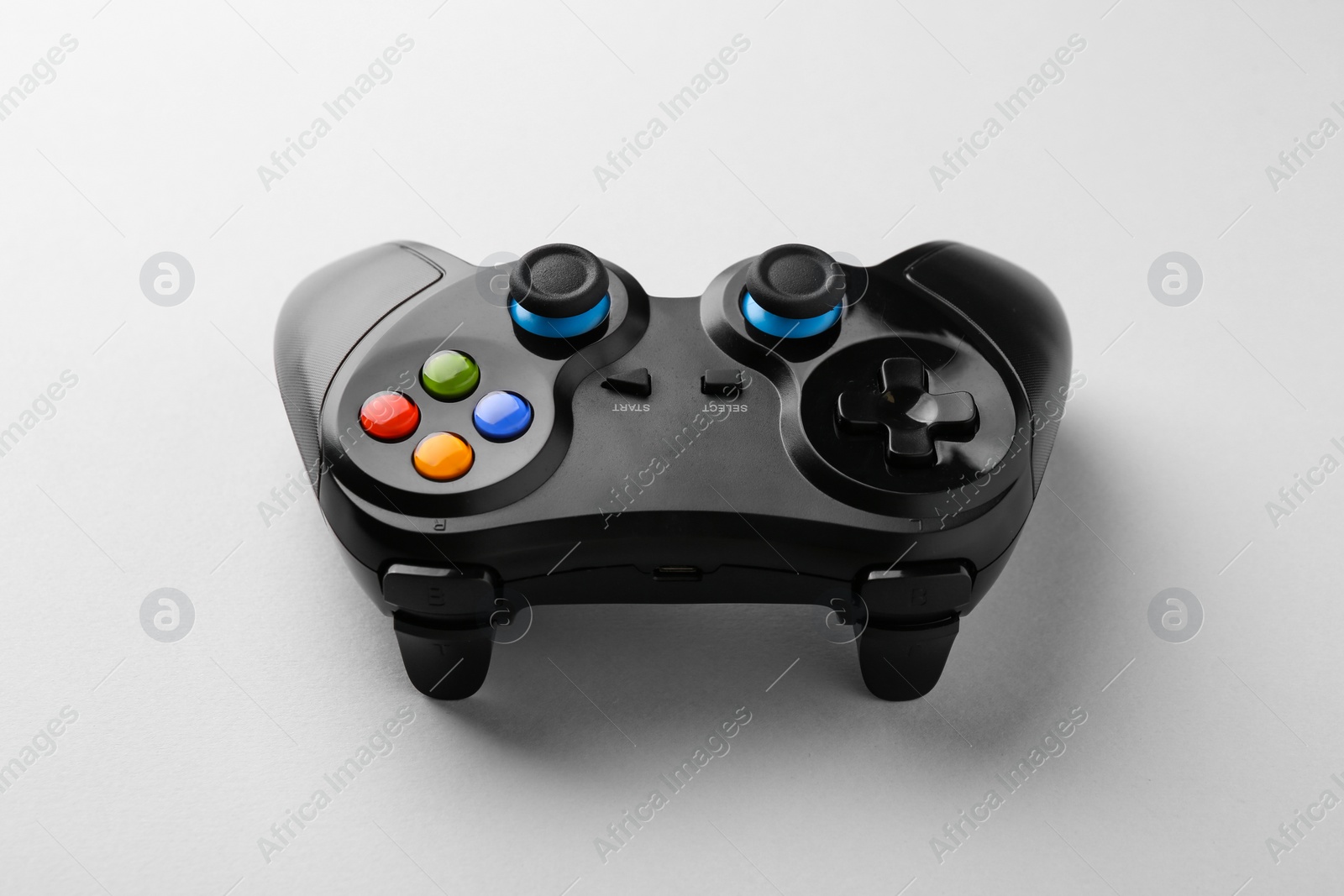 Photo of Black wireless game controller on light grey background