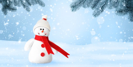 Image of Cute decorative snowman in hat and scarf outdoors on snowy day, space for text. Banner design