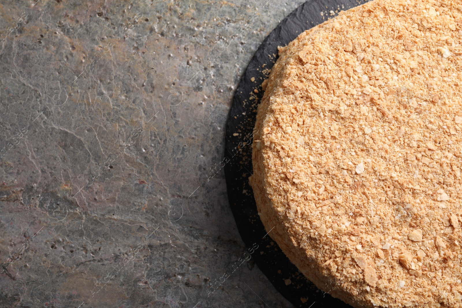 Photo of Delicious Napoleon cake on gray table, top view. Space for text