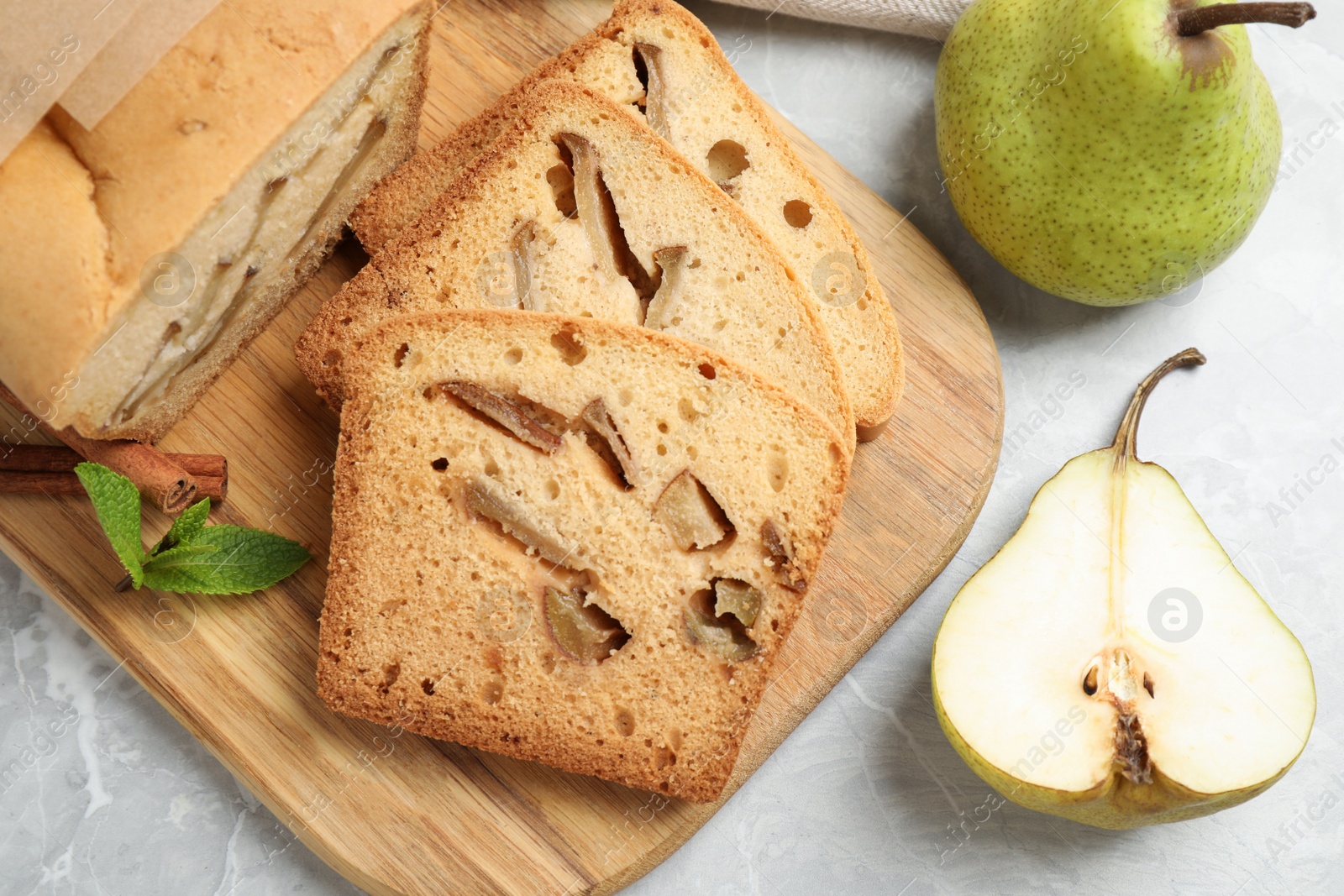 Photo of Tasty bread and pears on light grey marble table, flat lay. Homemade cake