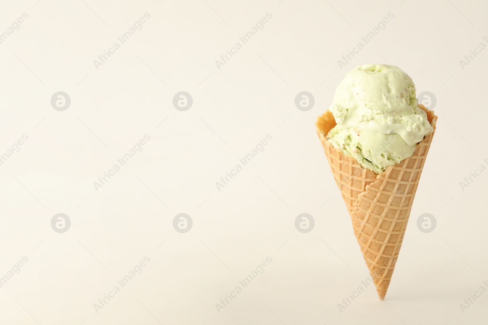 Photo of Delicious ice cream in waffle cone on white background. Space for text