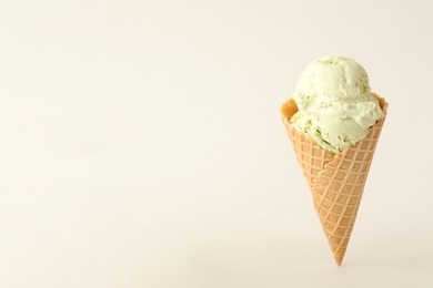 Delicious ice cream in waffle cone on white background. Space for text