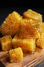 Photo of Fresh delicious sweet honeycombs on wooden board, closeup