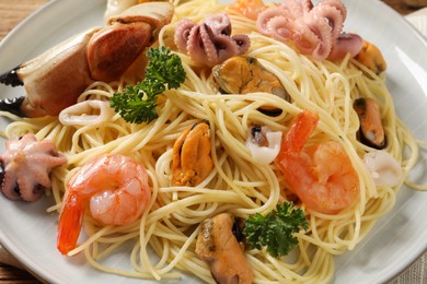 Delicious spaghetti with seafood on plate, closeup