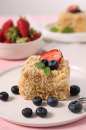 Photo of Piece of delicious Napoleon cake with fresh berries on table, closeup. Space for text