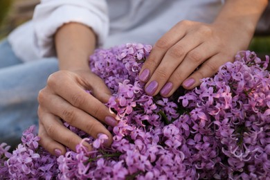 Photo of Woman with bunch of beautiful lilac flowers, closeup