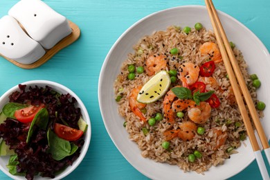 Photo of Tasty rice with shrimps and vegetables served on turquoise wooden table, flat lay