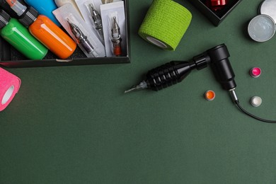 Photo of Flat lay composition with tattoo equipment on dark green background. Space for text