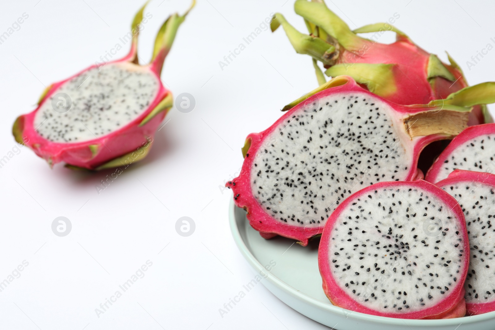 Photo of Delicious cut and whole dragon fruits (pitahaya) on white background