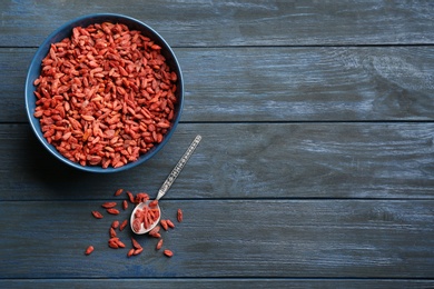 Flat lay composition with dried goji berries on blue wooden table, space for text. Healthy superfood