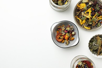 Photo of Different dry herbs and tea on white background, flat lay. Space for text