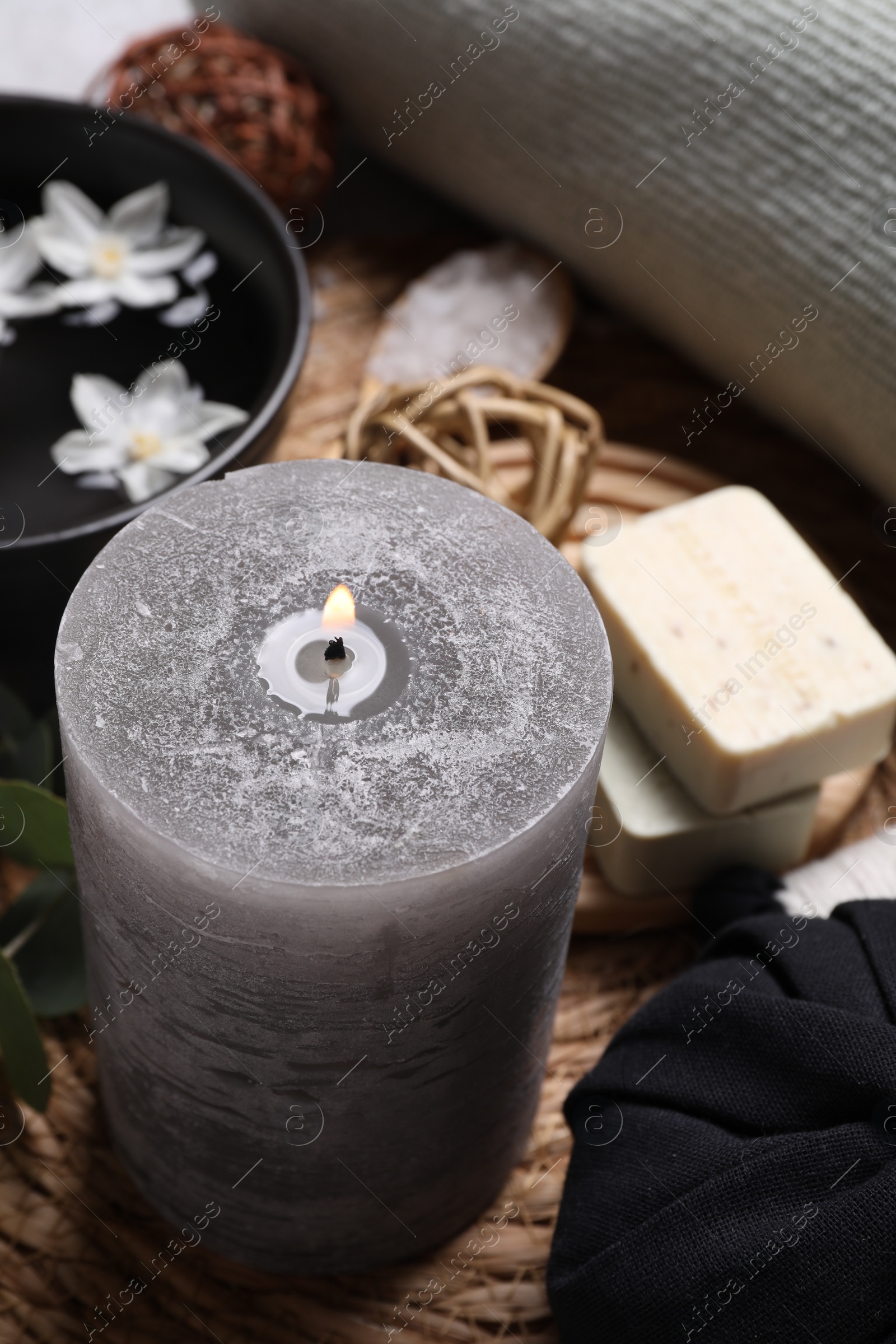 Photo of Beautiful composition with burning candle and spa products on table,closeup