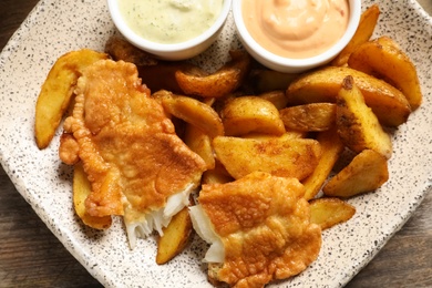 Photo of Plate with British traditional fish and potato chips, top view