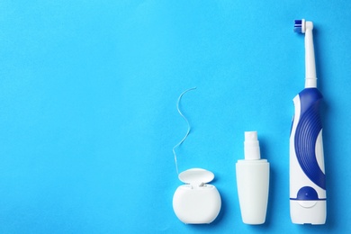 Photo of Flat lay composition with electric toothbrush and oral hygiene products on color background