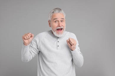 Photo of Portrait of surprised senior man on grey background