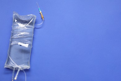 IV infusion set on blue background, top view. Space for text