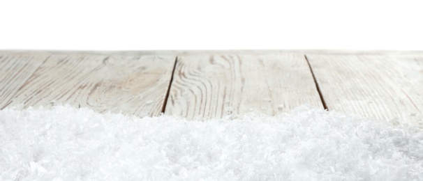 Photo of Heap of snow on wooden table against white background. Christmas season