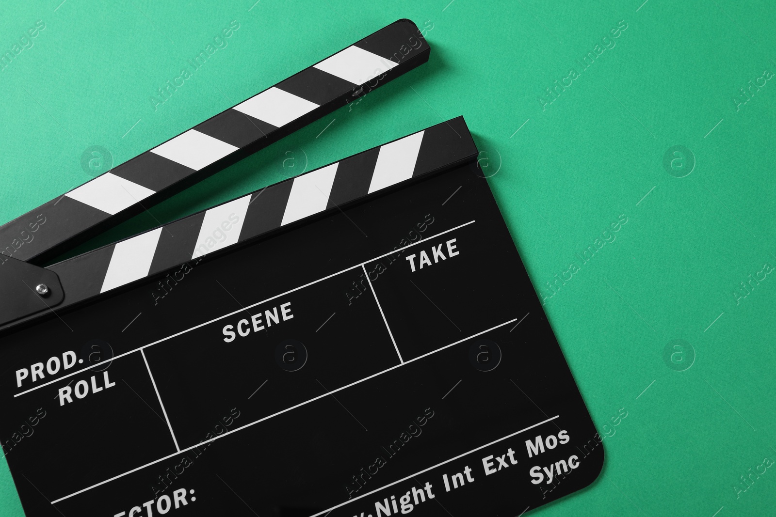 Photo of Clapperboard on green background, top view. Space for text