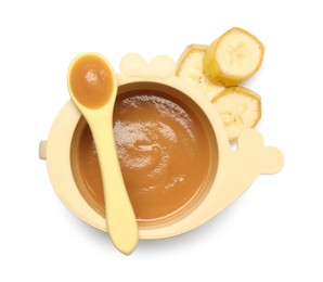 Delicious baby food in bowl, spoon and cut banana isolated on white, top view